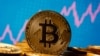 A representation of virtual currency Bitcoin is seen in front of a stock graph in this illustration taken November 19, 2020