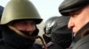 Лидер оппозиционной партии "Алга" Владимир Козлов (справа) разговаривает с полицейским на центральной площади города Актау. 21 декабря 2011 года. 
