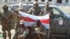 Украинские солдаты в Песках с национальным белорусским флагом на фоне автомобиля, купленного на собранные волонтерами деньги