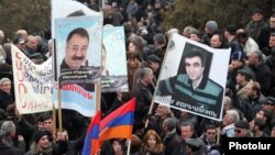 Demonstrators hold up pictures of jailed opposition members Aram Bareghamian (right) and Sasun Mikaelian at a rally on March 1.