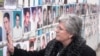 Nesrete Kumnova u Prištini ispred zida na kome se nalaze fotografije nestale djece, novembar 2007. godina