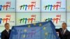 Прем’єр-міністри Польщі Дональд Туск (праворуч) та Угорщини Віктор Орбан тримають прапор Євросоюзу під час урочистої церемонії передачі головування у Раді Європейського Союзу, Варшава, 1 липня 2011 року