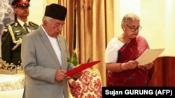 Nepal prezidenti Ram Çandra Paudel yeni təyin olunmuş baş nazir Suşila Karkiyə and içdirir.