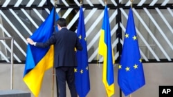 Član protokola sređuje zastave Ukrajine i EU tokom samita EU u zgradi Evropskog vijeća u Briselu u četvrtak, 9. februara 2023. 