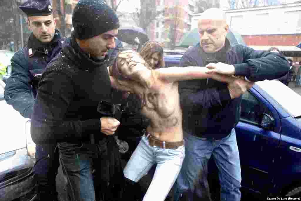Police drag Shachko away from the polling station in Milan where former Italian Prime Minister Silvio Berlusconi cast his vote in 2013.