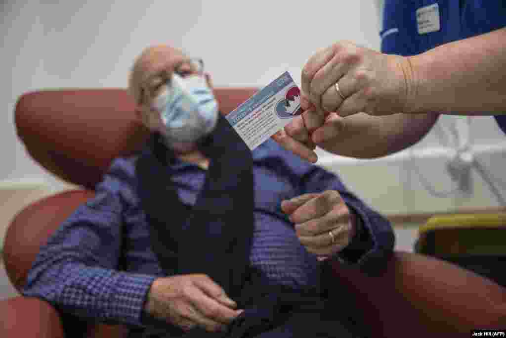 Medicinska sestra Naomi Walsh (desno) pokazuje Rogeru Shawu (87) karticu za vakcinaciju nakon što je primio vakcinu Pfizer-BioNTech protiv COVID-19 u Royal Free bolnici u Londonu 8. decembra 2020.