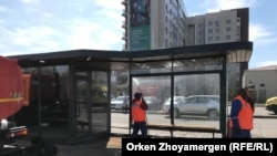 Рабочие моют остановку у здания цирка в Нур-Султане. 24 апреля 2021 года.
