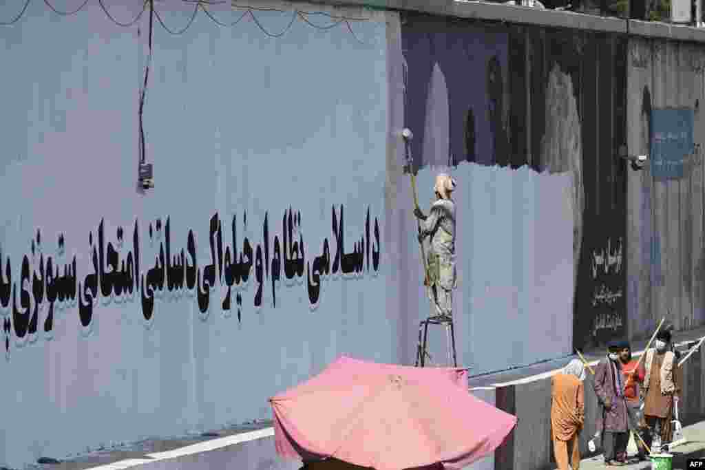 A wall is painted white with a message declaring: &ldquo;For an Islamic system and independence, you must endure tests and stay patient.&rdquo;